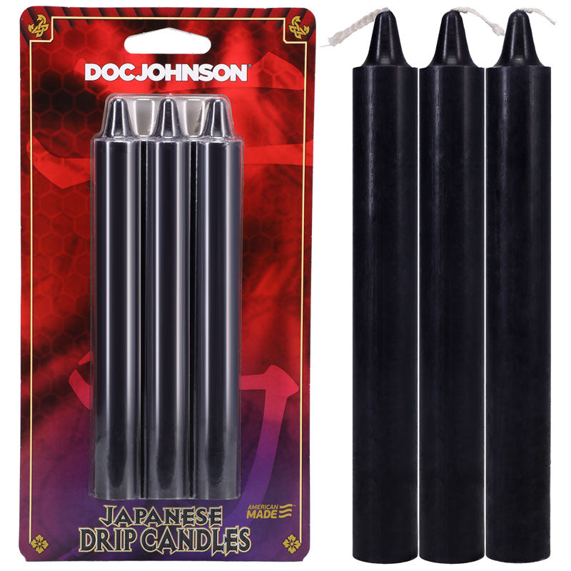 The packaging for Doc Johnsons Japanese Drip Candles - Black 3-Pack features a red background with decorative designs and gold accents, labeling Japanese Drip Candles at the bottom. Inside are three black candles each with a white wick, ideal for hot wax play.