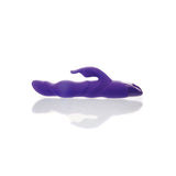 The Adam & Eve THE THRUSTER is a 25.4 cm purple, silicone vibrator with a thrusting shaft and curved external arm for ergonomic use. Displayed on a white surface, its sleek design is enhanced by soft lighting, giving it a modern and sophisticated appearance.