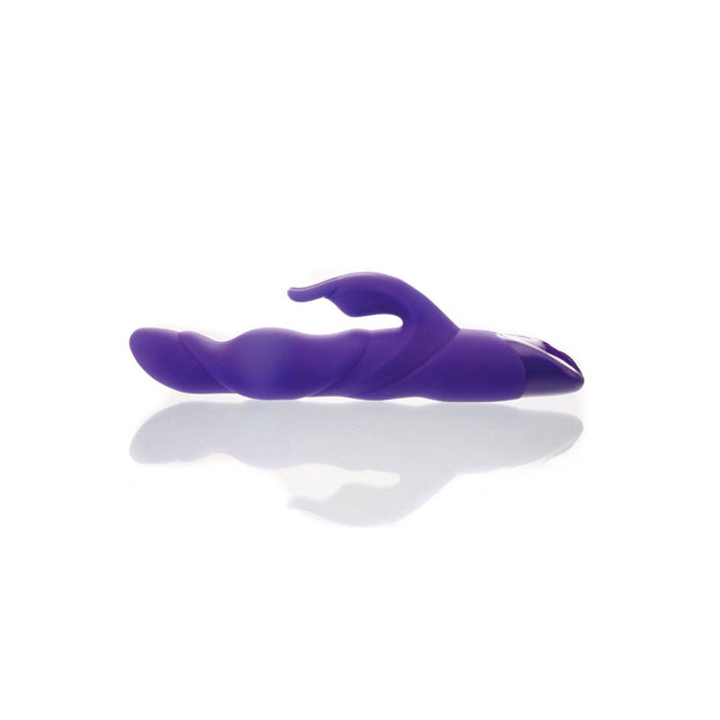 The Adam & Eve THE THRUSTER, a 25.4 cm purple silicone thrusting rabbit vibrator, boasts a curved, ribbed design with a smaller extension for dual stimulation. Positioned horizontally on a reflective white surface, it highlights its sleek and ergonomic form. USB rechargeable for convenience.