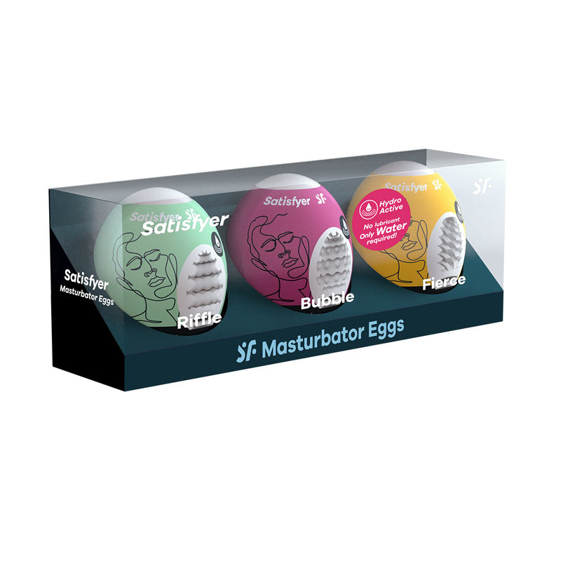 The Satisfyer Masturbator Eggs - Mixed 3 Pack #1 includes Riffle, Bubble, and Fierce designs in a sleek black box with white and colorful accents. These cyber-skin eggs are water-activated and discreet for travel.