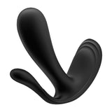 The black Satisfyer Top Secret +, a wearable vibrator, features smooth, organic lines and a glossy texture. Resembling fluid motion with upward asymmetrical extensions, it inspires clitoral stimulation and stands elegantly against a plain white background.