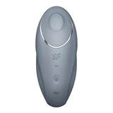 The Satisfyer Tap & Climax 1 in bluegrey is a handheld lay-on vibrator with a rounded top and silver trim. It has three buttons (minus, plus, wave) and the logo above them. Designed for smooth clitoral stimulation, this waterproof device is USB rechargeable.