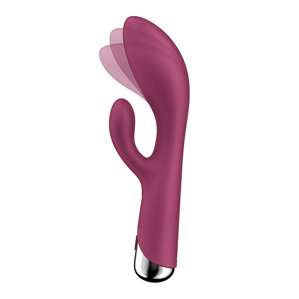 The Satisfyer Spinning Rabbit 1 is a red, dual-stimulation rabbit vibrator made from skin-friendly silicone. It has a curved shaft and a flexible attachment for simultaneous stimulation. The sleek, metallic base controls various vibration modes, with a motion-blurred image suggesting movement.