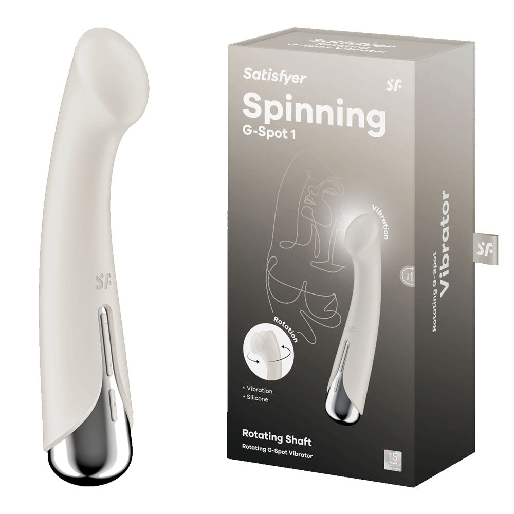 Image of a Satisfyer Spinning G-Spot 1 vibrator in beige, featuring a rotating shaft and vibration for targeted G-spot stimulation, is shown next to its packaging. The box highlights features with icons illustrating its USB rechargeable design and functions.