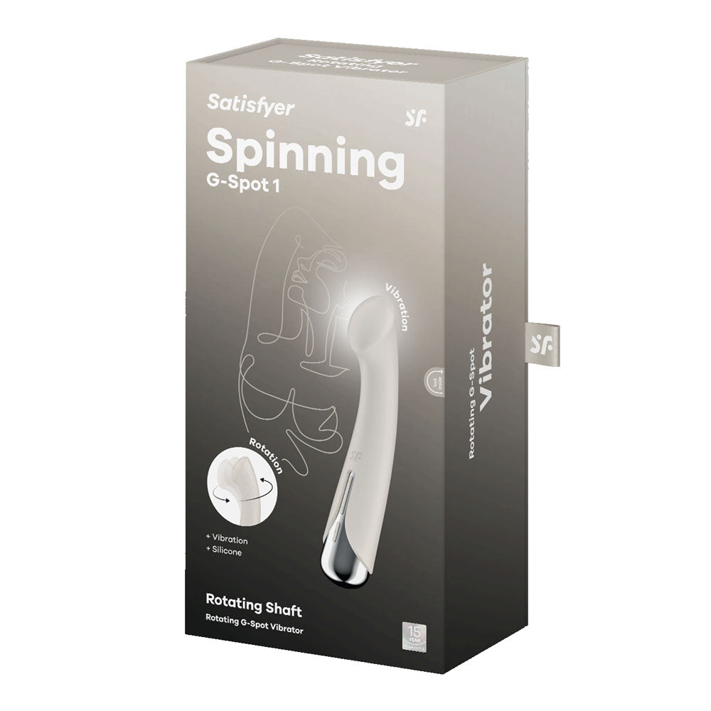 The image shows the packaging for the Satisfyer Spinning G-Spot 1 vibrator in beige, featuring a rotating shaft and silicone design. Text highlights intense vibration modes and emphasizes its spinning motion for maximum pleasure.