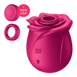 Introducing the Satisfyer Pro 2 Classic Blossom - a red, rose-shaped vibrator with Air Pulse Technology and two attachments, including a cap. With Wi-Fi and SF button logos suggesting connectivity, it features engraved petal details reminiscent of a blooming rose.