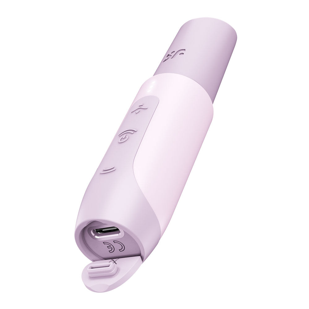 The Satisfyer Secret Kiss - Lilac is a sleek, elongated device with a discreet design and embossed icons. It features a removable cap revealing a micro USB port, and its travel-ready design includes a flip cover protecting the charging area at one end.