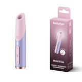 The Satisfyer Bold Kiss - Purple USB Rechargeable Air Pulse Stimulator features in an image with its luxury design in pink and lavender, along with control buttons. It stands upright next to packaging that highlights adjustable pressure wave intensities and branding details.