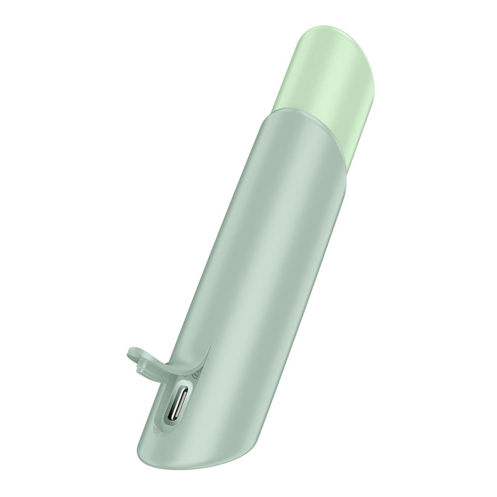 The Satisfyer Naughty Kiss - Mint Green USB Rechargeable Air Pulse Stimulator features a cylindrical design with a USB-C port and small loop, offering a waterproof build. Its slightly translucent top and smooth matte finish highlight its elegance against a white background.