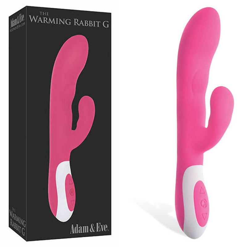 A pink, dual-ended massager with a curved G-Spot tip and shorter extension features a white base with control buttons. The warming vibrator is next to black packaging labeled The Warming Rabbit G by Adam & Eve, measuring 21.6 cm (8.5) and USB rechargeable.