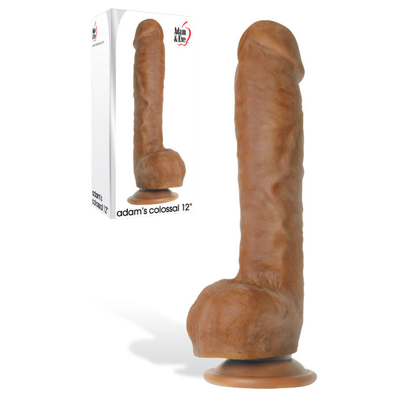 The Adam & Eve Adams Colossal 12 - Brown dildo stands upright with a suction cup base, textured veins, and a prominent head for authenticity. In the background, its packaging features branding alongside the impressive product.