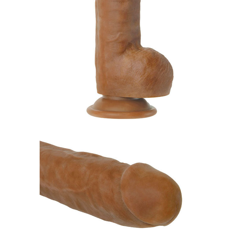 The Adam & Eve Adams Colossal 12 - Brown features a lifelike silicone design resembling male genitalia. It has a suction cup base for strap-on compatibility, and its brown-hued shaft and head have a realistic skin texture.