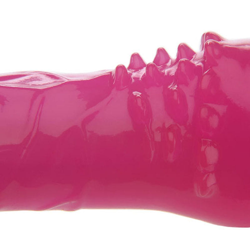 Close-up of Adam & Eves Slim Pink Pleaser, an 8-inch bright pink vibrator with a glossy, flexible rubber-like surface featuring irregular raised ridges and spikes, resembling abstract textures. Its waterproof for versatile use.