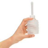 The AquaClean 300ml Enema Syringe, made from hypoallergenic materials, features a clear ribbed bulb with a long narrow nozzle for comfortable intimate hygiene. Its squeezable design offers better grip, and it includes a free travel douche. The setting is a plain white backdrop.