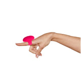 A hand features the Maia RUBY, a pink USB rechargeable finger stimulator on the index finger. Its rounded top showcases a sleek design, crafted from medical-grade silicone against a plain white backdrop, with fingers gently curved and thumb outward.