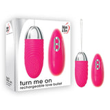 A pink Adam & Eve Turn Me On Rechargeable Love Bullet (8.9 cm) with a metallic tip is shown alongside its packaging, which features the text turn me on rechargeable love bullet. Made from body-safe silicone, it has a control button and the brand name on the box.