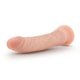 The Dr Skin Plus 9 Posable Dildo in flesh color lies against a white background, showcasing its lifelike design with visible veins. Made from body-safe TPE, this dildo features a rounded tip and gentle curve for realism.