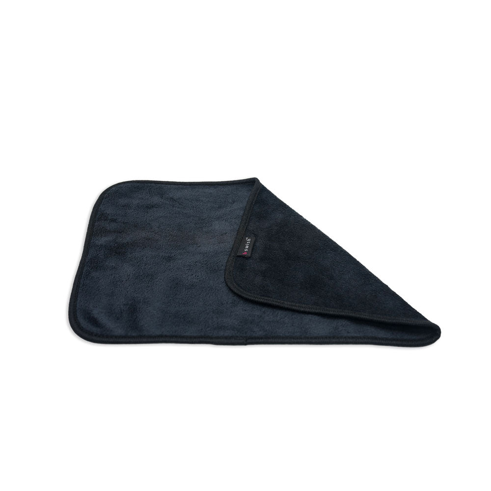 The B Swish After Sex Towel is shown in soft, dark gray microfiber. It features a slightly textured surface with rounded edges, folded to reveal both sides and a corner turned over. A small black tag with white text is visible near the turned corner.