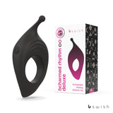 The image features the BCharmed Rhythm Infinite Deluxe by Bswish, a versatile black silicone vibrating cock ring. It boasts a curved design with a protruding nub, 15 vibration modes controlled by a power button, and comes in sleek white packaging with pink and black accents.