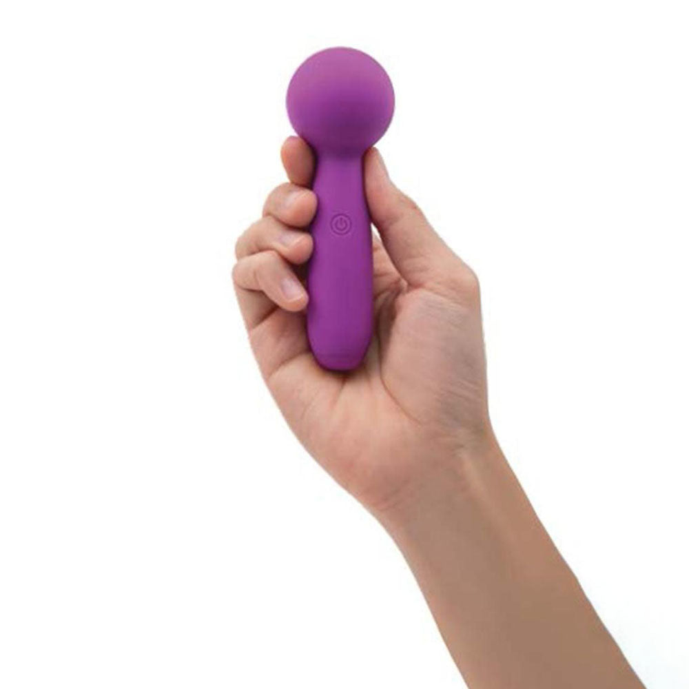 A persons hand holds the Bodywand Lolli Mini Wand against a pristine background. With its body-safe silicone finish, rounded head, cylindrical handle, and power button, it is designed for comfort and delivers powerful vibrations to soothe your senses.