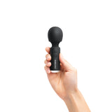 A hand holds the sleek Bodywand 4.5 Power Wand, a small black USB rechargeable massager with a rounded head and two-button handle, featuring beyond in white lettering. Set against a white background, it’s perfect for muscle stimulation and promoting sexual well-being.