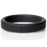 The Boneyard Silicone Ring 50mm, a black cock ring with 50 inscribed, sits against a white background. Its smooth texture and 3x-stretch design emphasize durability, while the lighting highlights its matte finish, making it a standout among male toys.