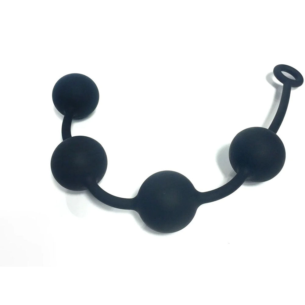 Boneyard Ass Ballz L in black features four equal-sized medical-grade silicone spheres on a flexible strand, finishing with a circular pull ring. They have a soft-touch finish, form a slight arc, and are set against a plain white background. Total length: 46 cm.