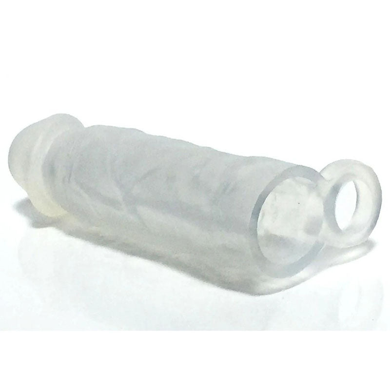 The Boneyard Meaty Cock Extender is a clear, cylindrical silicone sleeve with a textured surface and an extra loop or ring for added sensation, designed to encase or protect. It is shown laid horizontally on a reflective white surface.