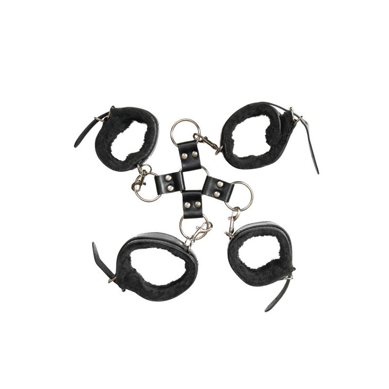 The Adam & Eve Hog Tie - Black Restraints are four black leather and faux fur wrist cuffs linked by a central metal hub with rings, creating an X shape when laid flat. Each cuff features adjustable buckles and straps for secure, comfortable BDSM experiences.