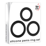 The image features the packaging of the Adam & Eve Silicone Penis Ring Set - Black Cock Rings - Set of 3 Sizes. Three black rings, aimed at prolonging erections, are arranged in a triangle. The brand logo is in the top right corner, and the product name is in lowercase letters at the bottom.