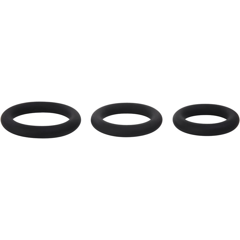 Against a white background, three black Adam & Eve silicone penis rings are aligned horizontally. The rings vary in size from left (largest) to right (smallest). Each ring is smooth, circular, and designed to effectively prolong erections.