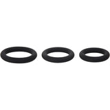 Against a white background, three black Adam & Eve silicone penis rings are aligned horizontally. The rings vary in size from left (largest) to right (smallest). Each ring is smooth, circular, and designed to effectively prolong erections.