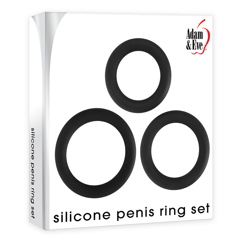 The image shows an Adam & Eve package containing a set of three black silicone penis rings designed to strengthen erections, arranged in a triangular layout. The primarily white packaging labels it as the Adam & Eve Silicone Penis Ring Set - Black Cock Rings - Set of 3 Sizes.