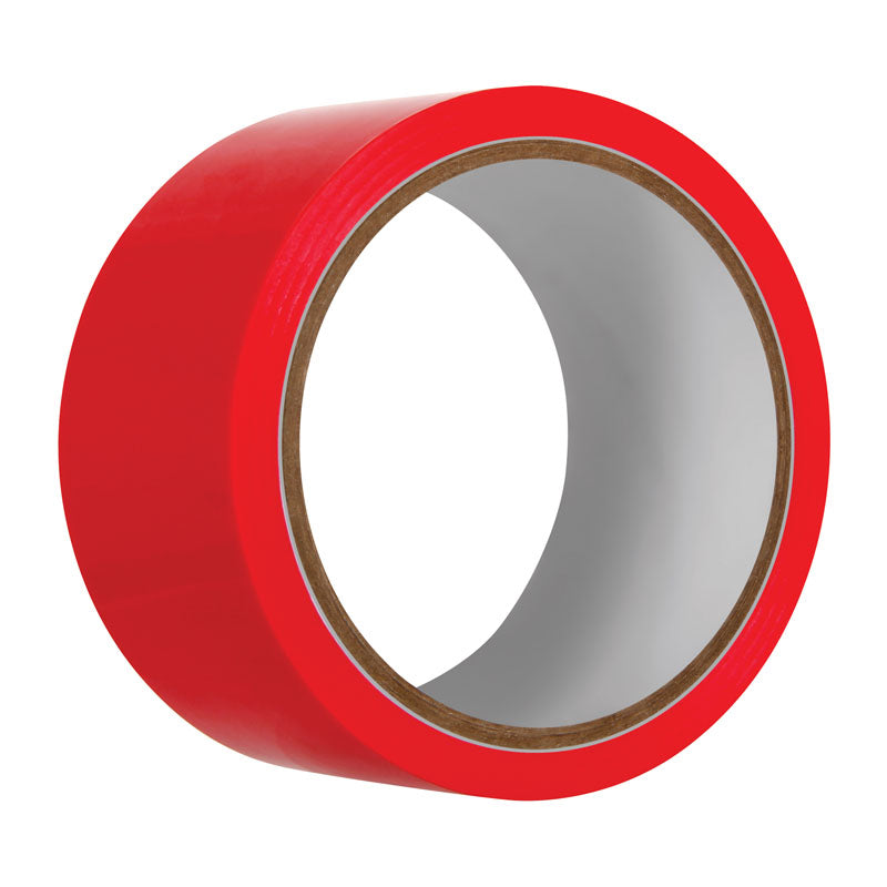 The Evolved Red Bondage Tape is shown upright, its glossy PVC vinyl surface emphasizing its bright red color. With a white center and brown inner core, shadows highlight its thickness and texture, showcasing the self-adhesive properties of this 20-metre length tape.