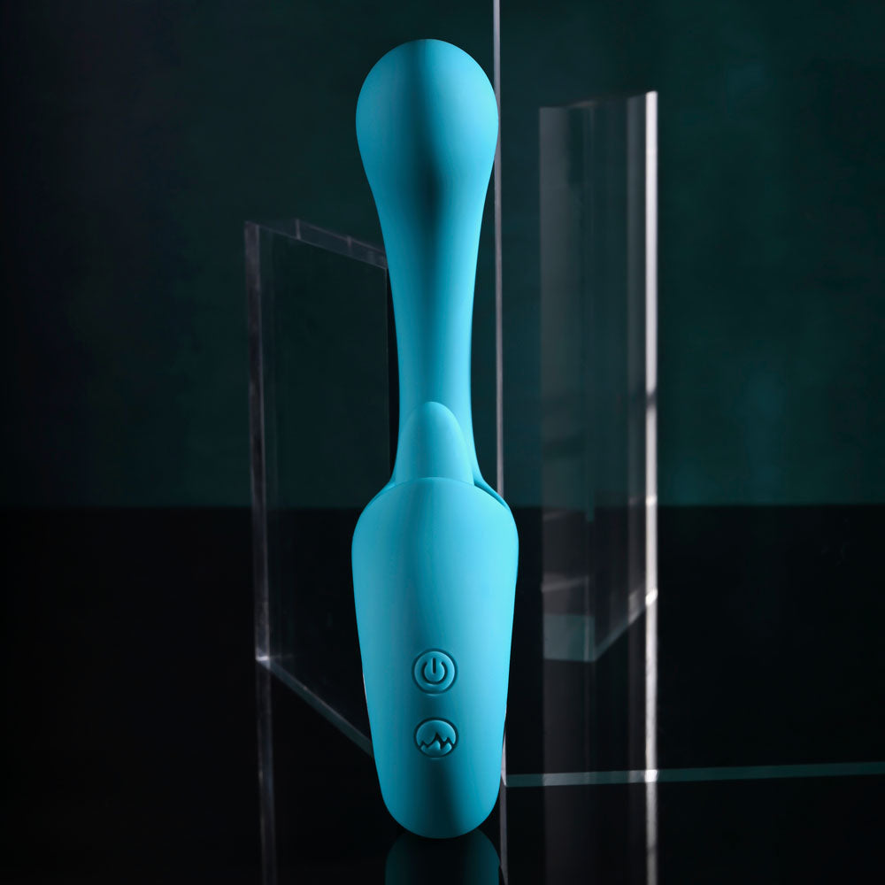 The Evolved HOW MANY LICKS 17.8 cm USB Rechargeable Vibrator in blue features a curved G-Spot head with a smooth, bulbous top and two control buttons on the handle. Vertically positioned against a reflective surface, it creates a mirrored effect, with an angled transparent acrylic sheet against a dark background.