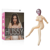 Box for the Hussy - Gwen - Inflatable Love Doll shows a woman in lingerie and veil. Next to it, the partially inflated doll flaunts exaggerated traits, an open mouth, large breasts, and three love holes for realism.