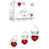 Product image of Adam & Eve RED HEART GEM GLASS PLUG SET featuring clear glass butt plugs in small, medium, and large sizes, each with a red heart-shaped base. The box displays small, medium, large alongside a charming description.