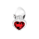 The Adam & Eve RED HEART GEM GLASS PLUG SET features metallic, egg-shaped clear glass butt plugs with a reflective silver finish and heart-shaped red crystal bases that capture light for a vibrant sparkle. A clear border enhances their jewel-like appearance.