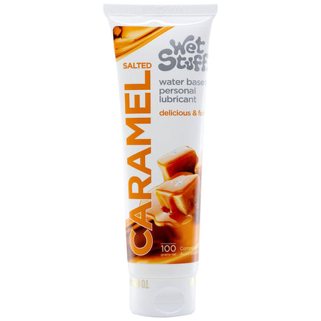 A 100g tube of Wet Stuff Salted Caramel lubricant, featuring white packaging with caramel pieces and orange-black text. Its clearly labeled delicious & fun, offering a hypoallergenic, water-based sweet experience.