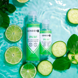 Two bottles of Gender X SPA DAY Flavoured Lube (60 ml), mint, lime, and cucumber flavor, rest on a light blue watery surface, surrounded by fresh lime slices, cucumber rounds, and mint leaves for a refreshing spa-like vibe.