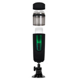 Exploded view of the Gender X MESSAGE IN A BOTTLE - USB Rechargeable Thrusting & Spinning Masturbator shows a black device with green accents, a detachable cap, cylindrical compartment, control buttons, and suction cup base for secure placement. The textured inner channel enhances its functionality.