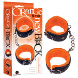 Packaging labeled Orange Is The New Black - Love Cuffs - Wrist features black fluffy wrist restraints with orange faux-fur, strong chains, and adjustable buckles for a perfect fit. Elegance meets excitement at an economical price with the iconbrands logo visible.