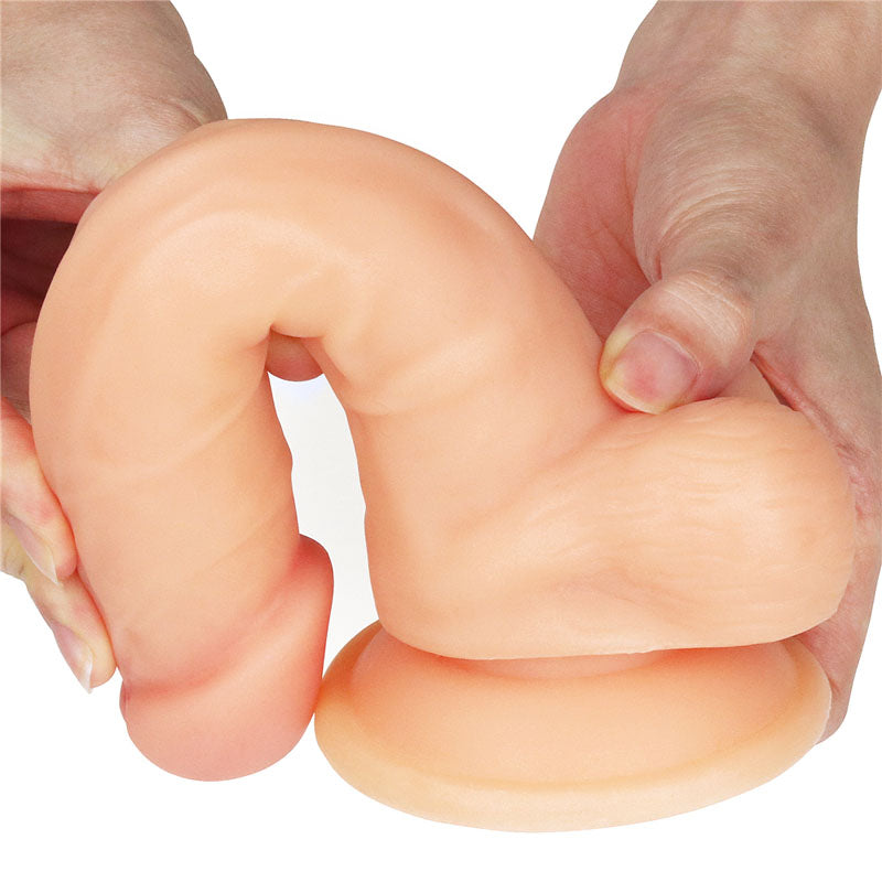 Two hands present The Ultra Soft Dude - Flesh 20.3 cm (8) Dong, highlighting its ultra-soft, flexible, and textured design with realistic details and a suction cup base, demonstrating its bendability against a plain white background.