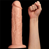 A King Size 11 Realistic Dildo - Flesh 28 cm Dong stands upright with detailed veining and a suction cup base on the left. On the right, a human arm with a clenched fist is vertically positioned for scale against a black background.