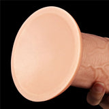 Close-up of a person holding the King Size 11 Realistic Dildo - Flesh 28 cm Dong with a round suction cup base against a black background. The base is smooth, while the textured cylindrical body features lifelike ridges and veins for added realism.