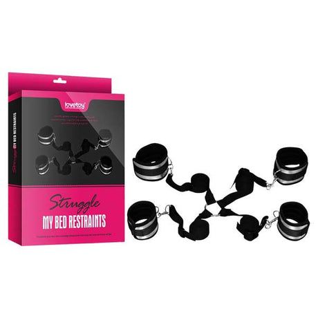 The Struggle My Bed Restraints - Wrist & Leg Cuffs Kit comes in a sleek black and pink box, showcasing an enticing image of the adjustable setup. It includes adjustable black cuffs connected by straps for secure bed attachment and enhanced comfort during play.