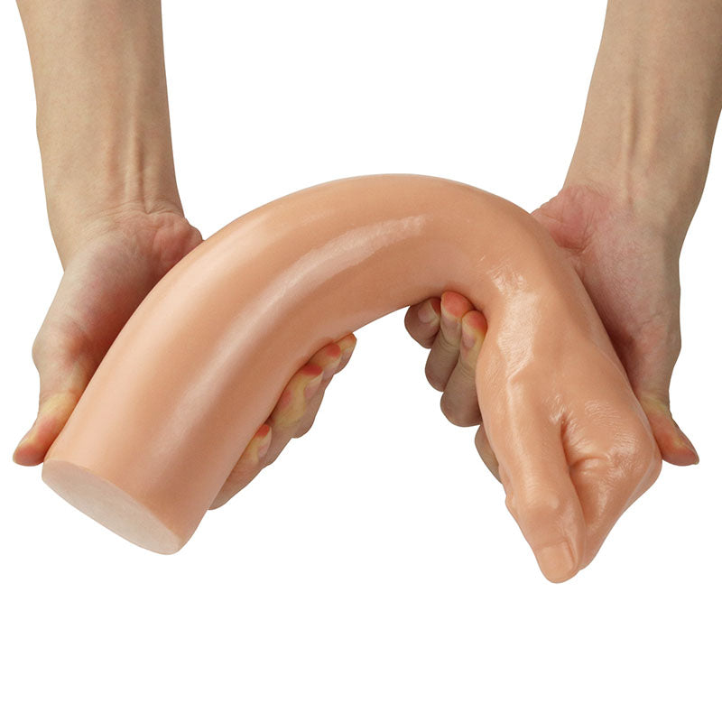 Two hands hold the King Sized 12 Realistic Bitch Fist Dildo, a large, curved, flesh-colored object resembling a tentacle or elongated hand. The U-shaped design is both pliable and phthalate-free, promising a realistic experience against the plain white background.