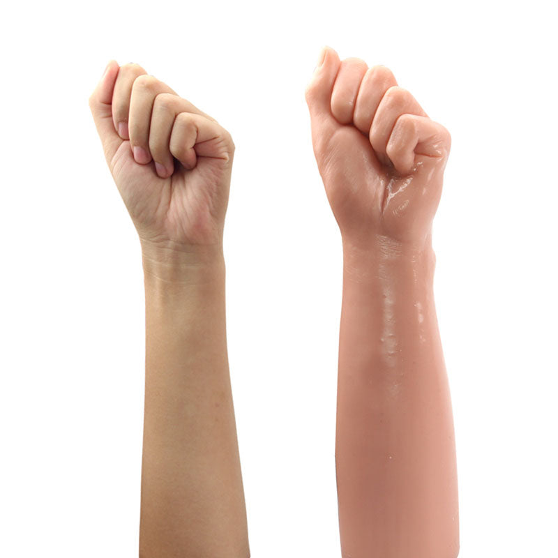 The King Sized 12 Realistic Bitch Fist - Flesh (30.5 cm) displays a realistic human arm with a closed fist alongside a phthalate-free prosthetic arm, both positioned vertically against a white background. The prosthetics shiny surface contrasts with the natural look of the real arm for authenticity.