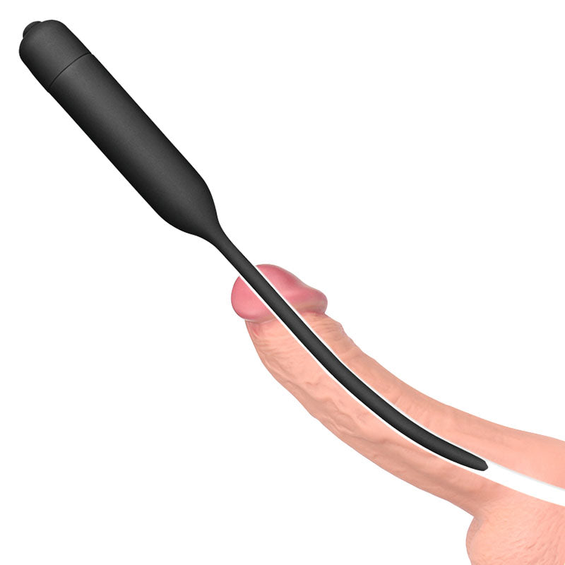 A digital illustration shows the Ultimate Silicone Vibrating Urethral Dilator in black, parallel to a flaccid penis. The design is long and slim with a bullet-shaped handle, intended for deep penetration.