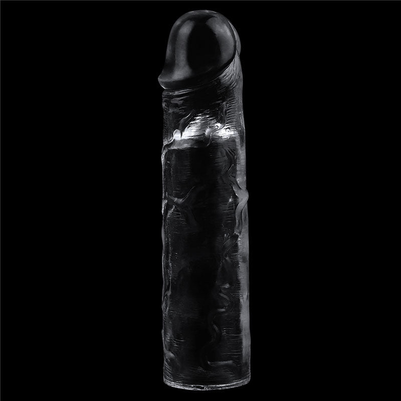 The Flawless Clear Penis Sleeve resembles a textured cylinder with an asymmetrical, rounded top. Its clear surface features intricate patterns that reflect light, creating dynamic highlights and shadows against a solid black background.